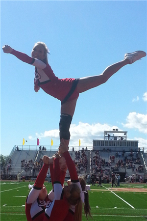 Cheerleader supporting game with balance and grace
